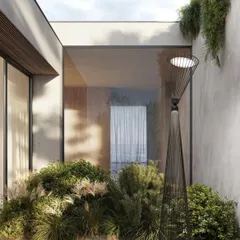 The Ikonika floor lamp placed on a wooden deck amidst lush greenery. It provides soft, diffused lighting, enhancing the environment and extending the usability of the outdoor space into the evening.