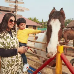 Our event photography goes beyond the party hall. Here, we captured a tender moment between a mother and her son as he gently pets a horse at his farm-themed birthday party, creating a memory of a unique experience.