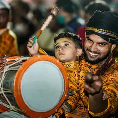 A heartwarming moment of tradition being passed down, as a father teaches his young son how to play the dhol.