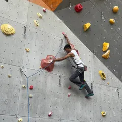 A climber makes a big move on one of our lead routes. Lead climbing requires technique, strength, and mental focus, and our walls are set to challenge you.