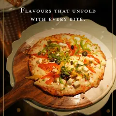 A colourful vegetarian pizza, generously topped with bell peppers, olives, and paneer. Baked fresh at our live stations, each slice unfolds with flavour.