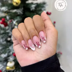 A full view of the Christmas-themed French manicure, showing the almond-shaped nails with cute bow and snowflake details.