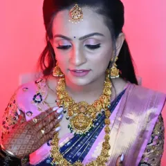 This bride is admiring her final look. The soft pink lighting highlights the glow on her skin and the intricate gold jewellery.