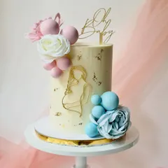 An elegant "Oh Baby" shower cake. The design features a gold line art graphic of an expecting mother, accented with pink and blue spheres and flowers.
