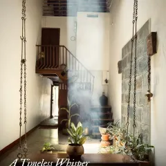 A timeless whisper from the past. In this 200-year-old ancestral home, a beam of light illuminates a space defined by raw materials and quiet contemplation, showcasing our approach to heritage restoration that honors history while creating serene living environments.