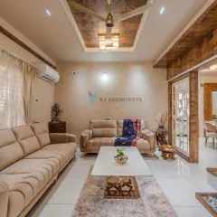 The living room is designed for comfort, with plush sofas and a neutral color scheme. We used a textured wooden ceiling panel and wood-paneled partitions to add warmth and define the open-plan layout.
