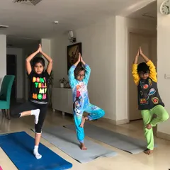 Finding their balance in Tree Pose (Vrikshasana). I guide children through classic yoga poses in a way that feels like a game, helping them develop focus and stability.