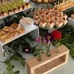 An elegant spread of sweet and savory appetizers. I use multi level stands and fresh floral arrangements to create a visually stunning display that invites guests to explore the menu.
