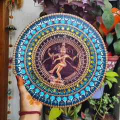 The finished Nataraja dot mandala art, held against a natural background. The blues, yellows, and gold create a vibrant yet harmonious effect.