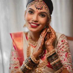 A happy bride ready for her big moment. This close-up showcases the complete Muhurtham look, from the intricate matha patti and nose ring to the layers of beautiful necklaces.