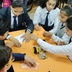 Collaboration is key to innovation. Here, a team of students works together to assemble and wire their robotic car during one of our hands-on school workshops.