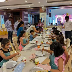 This is what a creative party setup looks like. A long table filled with kids in aprons, completely absorbed in their painting. I make sure every child has their own station with all the supplies they need to get started.