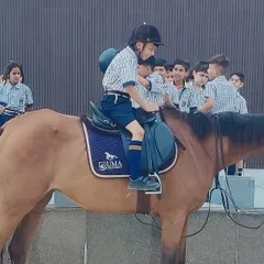 A child gets assistance mounting a horse for the first time. We make sure every new rider's first experience is positive and confidence-building.