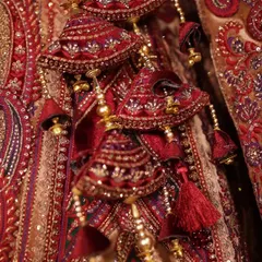 A close-up shot of the intricate tassels and embroidery on the bride's wedding lehenga, showcasing the craftsmanship of her attire.
