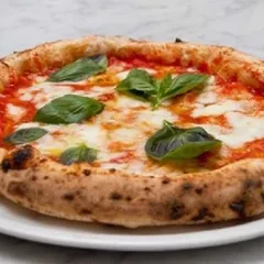 The quintessential Neapolitan pizza: the Margherita. This simple yet perfect pizza features San Marzano tomato sauce, fresh mozzarella, basil, and a drizzle of olive oil on a beautifully baked crust.