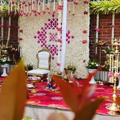 A closer look at the Seemantham stage. The backdrop is a wall of white jasmine flowers with a geometric pattern made of pink flowers, creating a fragrant and beautiful setting for the ceremony.