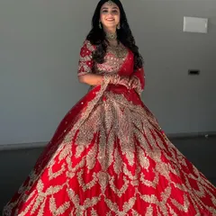For a reception or sangeet, I love creating glamorous looks like this. This bride is wearing a stunning red and gold lehenga, and I've designed a bold makeup look with soft waves to match the celebratory feel of the event.