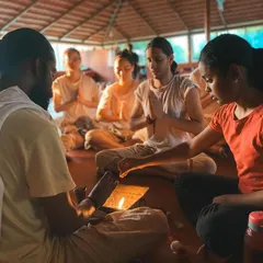 A student participates in a lamp lighting ceremony, a beautiful ritual symbolizing the dispelling of darkness and the welcoming of knowledge. Each flame represents the inner light we seek to awaken through our practice.