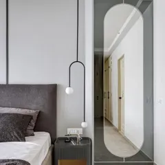 We love playing with reflections. A full-length mirror, tinted in grey, creates an illusion of depth and reflects the clean lines of the bedroom. The muted grey walls and custom bedside table complete this picture of modern sophistication.