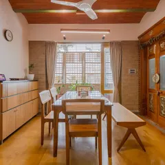 The dining area sits under a jack-arch roof, a traditional technique that adds character and volume. The space opens to a sit-out, blurring the line between inside and outside.