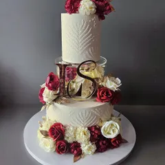 For a truly grand celebration, you need a cake to match. This three-tier wedding cake features a modern spacer, elegant stencil work, and a cascade of beautiful maroon and white sugar flowers. It’s a statement piece, designed to be as memorable as the special day itself.