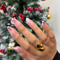 A delicate and festive take on the French manicure, with hand-painted red bows and a snowflake on a classic white tip.
