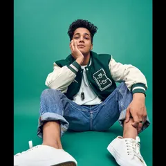 Another shot from the same portfolio session. This angle gives a more relaxed, contemplative feel to the same varsity look, showing the model's range.