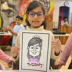 A young guest at a birthday party in Vashi, looking very pleased with her caricature. This makes for a wonderful and personal return gift.