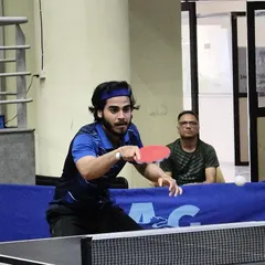 An athlete in the zone, preparing to return a serve during a competitive match. The mental aspect of the game is as important as the physical, and we train our players to be strategic thinkers.