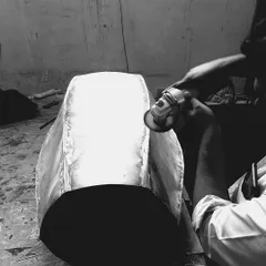 The raw form of a custom table base being meticulously finished by hand. This level of craftsmanship ensures that every piece of bespoke furniture is a work of art.
