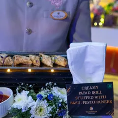 A server presents our Creamy Papad Rolls, stuffed with basil pesto paneer. This dish is a perfect example of our progressive Indian cuisine, fusing traditional textures with contemporary global flavours.