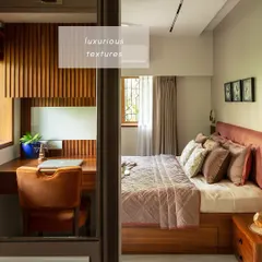 A bedroom should be a serene retreat. In the 'Calm Abode' project, we designed a master suite that combines luxurious textures with the richness of wood. This view shows the seamless integration of a walk-in closet and a dedicated study area, proving that functional design can also be beautiful.