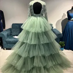 The back view of the pastel green gown, showcasing its voluminous layers and daring open back. A true showstopper.