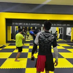 A look at a kickboxing class in session. The mirror helps students check their form while they practice. The quote on the wall says it all: "If you want to be a champion, you need to train like one."