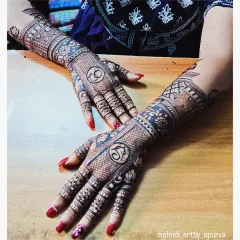 A perfect example of engagement mehendi. The initials of the couple, 'S' and 'K', are the centerpiece of the design on the back of the hands, surrounded by intricate patterns.