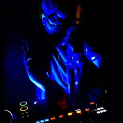 A close-up shot of me mixing under cool blue lights. This is my office, where I blend sounds and create energy for the dancefloor.