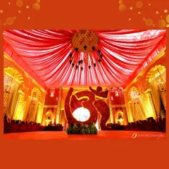 A sacred "Om" symbol, created entirely from red flowers, serves as a powerful and spiritual centerpiece for this traditional Indian wedding.