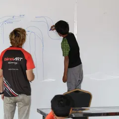 Success starts in the briefing room. Our expert coaches break down complex track dynamics and racing lines on a whiteboard, providing the theoretical foundation our drivers need to win.