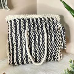 A classic that never goes out of style. This black and white macrame tote bag is spacious enough for all your essentials, featuring a thick, comfortable handle and a playful matching tassel.