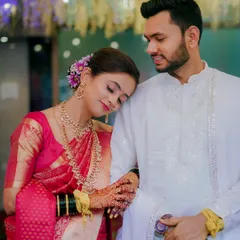 A moment of quiet comfort as the bride rests her head on her partner's shoulder. Her beautiful pink saree and traditional jewelry shine in this heartfelt portrait.