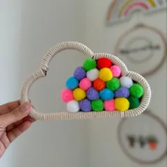 Brighten up a kid's room with this whimsical cloud wall hanging, filled with a rainbow of colorful pompoms. It's a fun and cheerful piece of decor.
