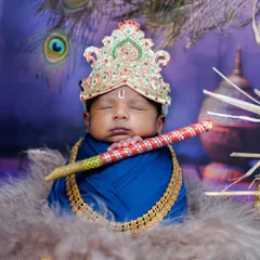 I have a huge collection of themes to make your baby's first photoshoot truly special. This Little Krishna setup is a favorite, complete with a tiny flute, peacock feathers, and a divine, sleepy expression.