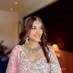 A smiling portrait of the bride's sister. Her makeup is soft and pretty, with a natural finish that looks beautiful in the daytime wedding light.