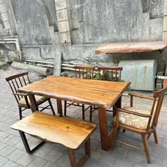 A rustic dining set featuring a live-edge solid wood table, matching bench, and classic armchairs. This set perfectly blends natural and refined elements.