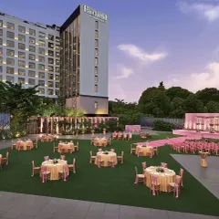 I transform open lawns into sophisticated event spaces perfect for corporate galas, client appreciation dinners, or daytime conferences. This wide-angle view shows a meticulously planned layout with coordinated table settings and a clean, professional stage backdrop against the hotel's grand architecture.