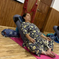 In this supported Baddhakonasana (Bound Angle Pose), a strap helps gently open the hips while the bolster supports the spine. This is a wonderful pose for releasing tension in the lower body.