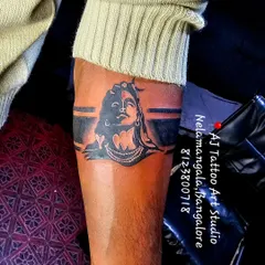 A bold black armband featuring a silhouette of Lord Shiva, a unique and modern take on a spiritual tattoo.
