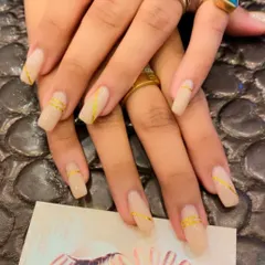 A minimalist and chic design on long, square nails. The nude base is accented with a simple, thin gold line running down the center of each nail.