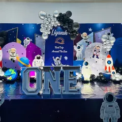 An out-of-this-world space theme for a first birthday party. I designed this entire stage with astronaut cutouts, rocket ships, planet props, and a floor that looks like the galaxy.
