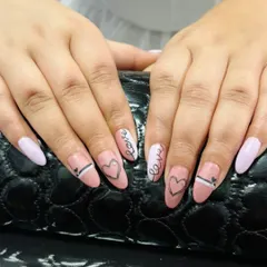 A romantic and modern set featuring a mix of solid light pink nails and sheer pink nails with hand-drawn hearts and the word "Love" in script.